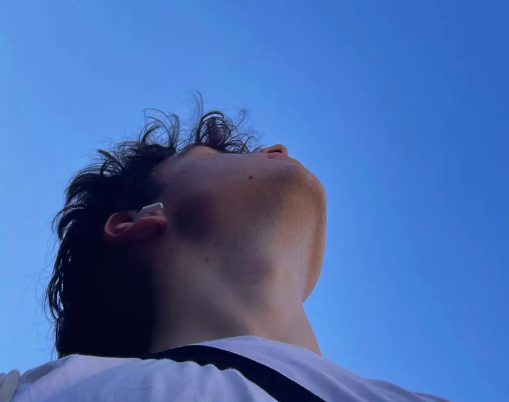 Junge der in den blauen Himmel guckt