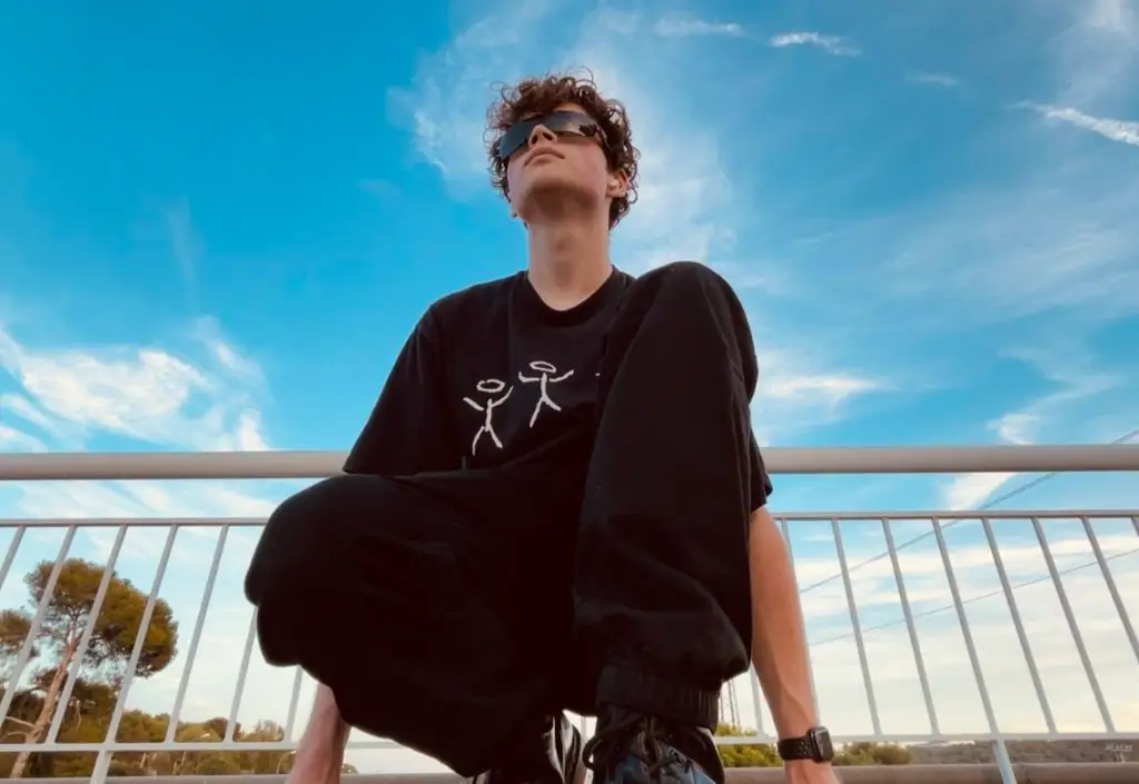Junge mit Sonnenbrille auf dem Boden hockend